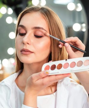 make-up-artist-applying-eyeshadow-on-woman-with-brush